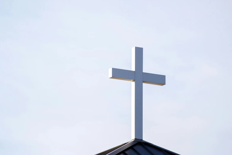 a cross on top of the roof of a church