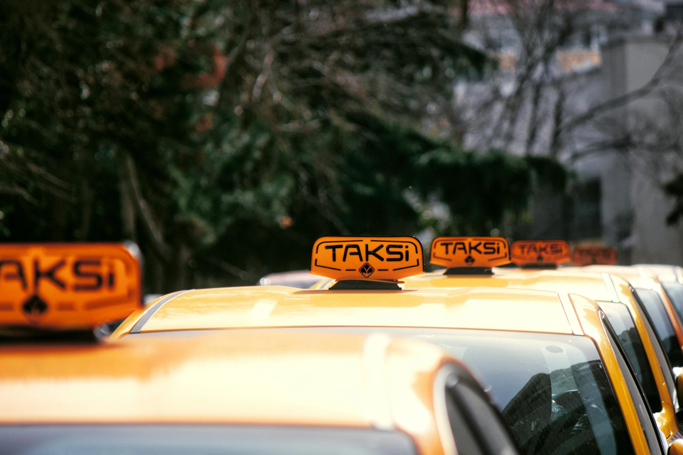 a taxi cab parked in front of some trees and buildings