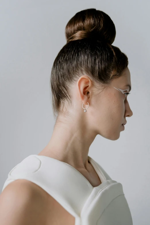 a woman in an updo has clear, minimal sunglasses on her face