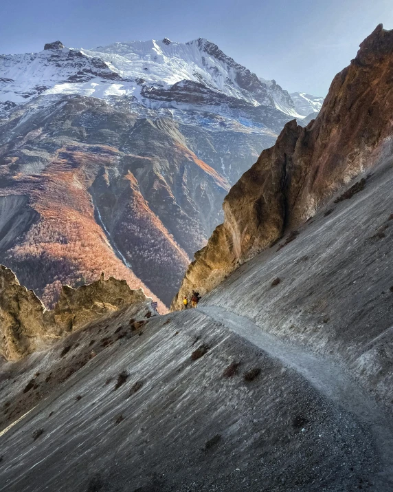 a group of hikers hiking uphill on the side of mountains