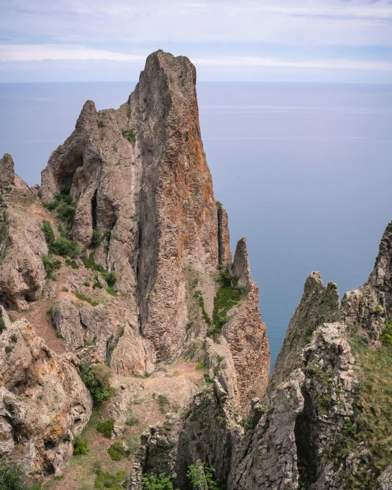 a mountain with rocks overlooking the ocean