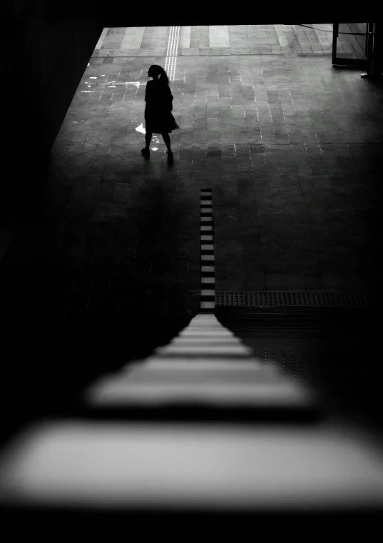 woman in black and white standing near dark doorway