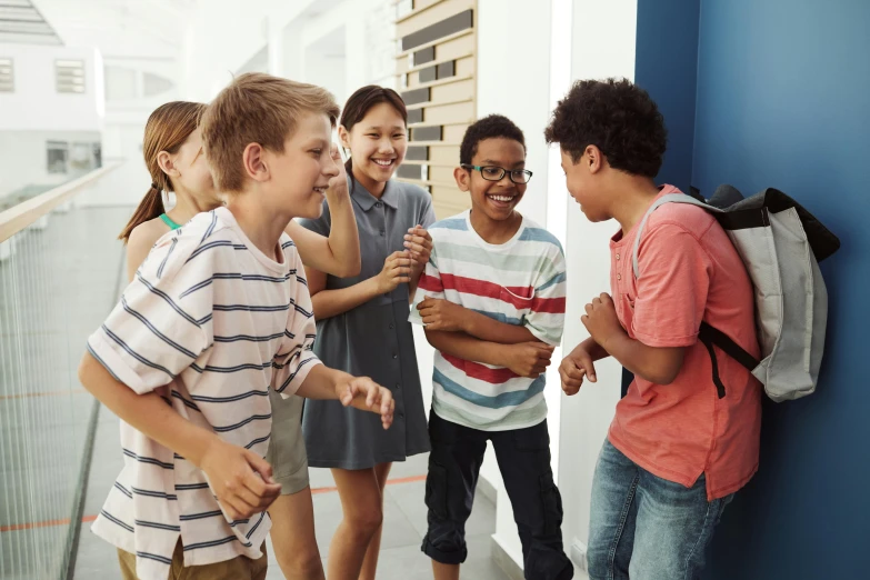 several children standing and talking in a hallway