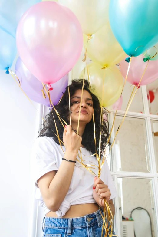 a woman holds several balloons in her hands
