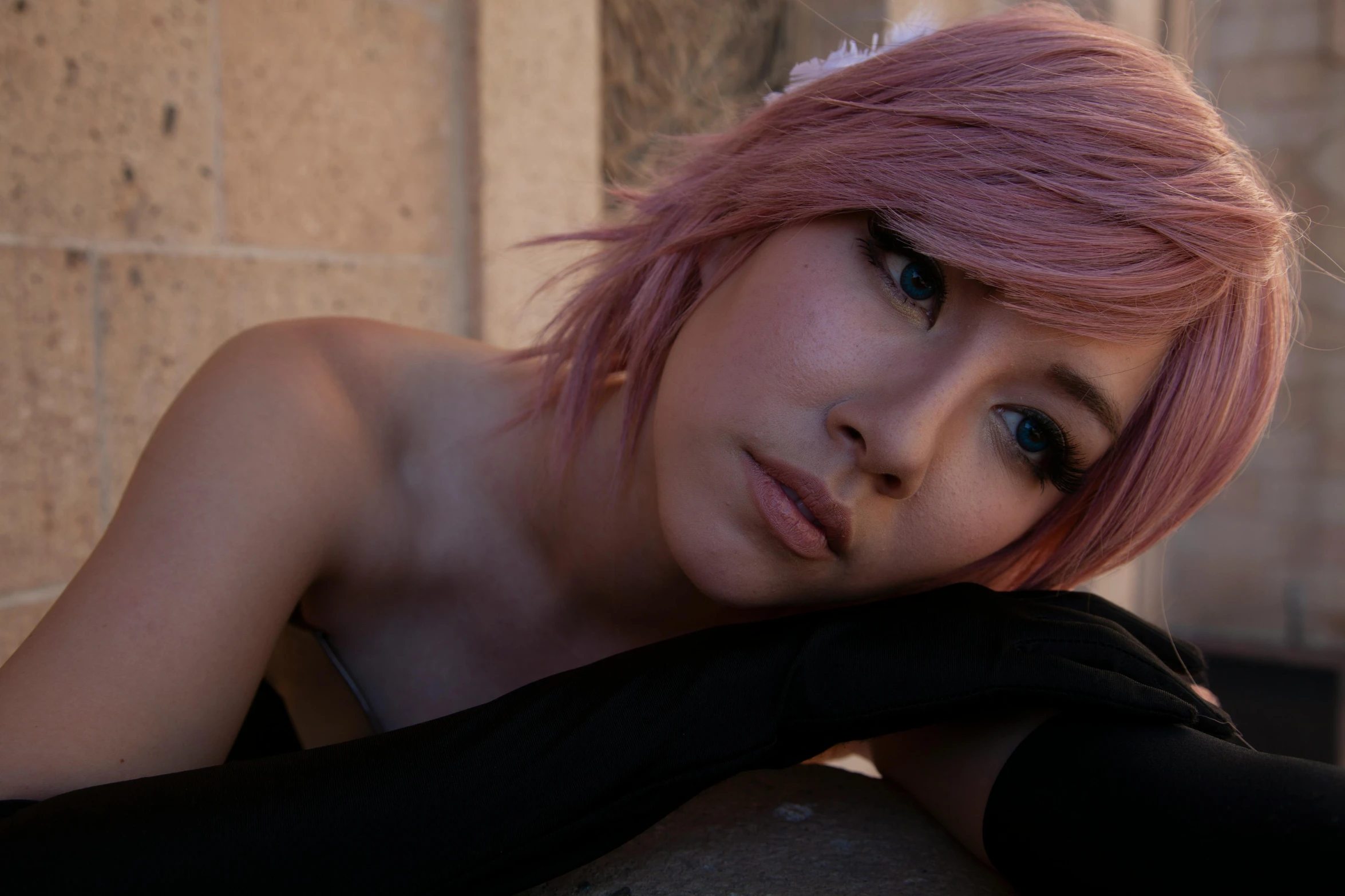 a woman with pink hair and black gloves posing