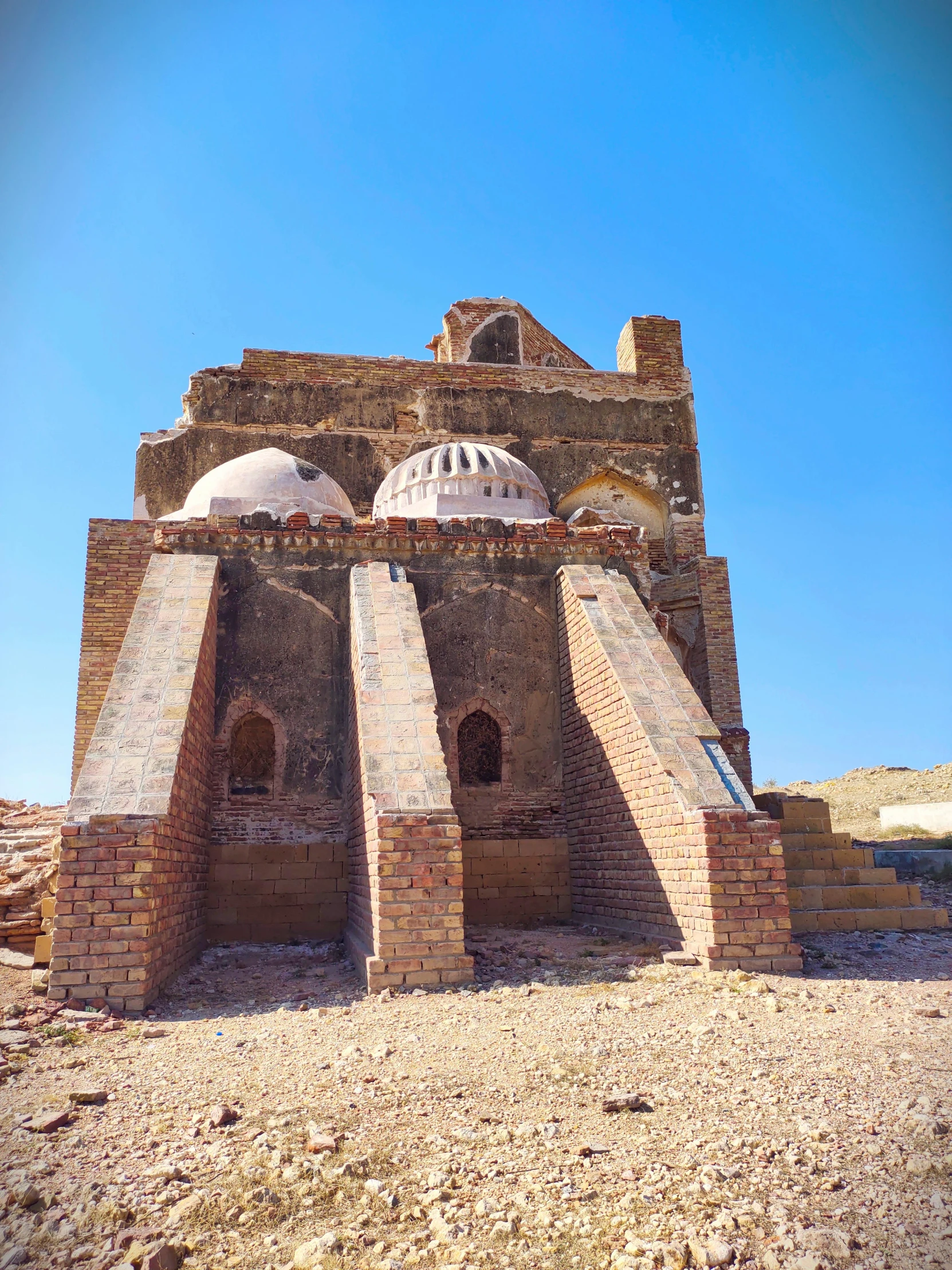 a large stone structure with pillars underneath it