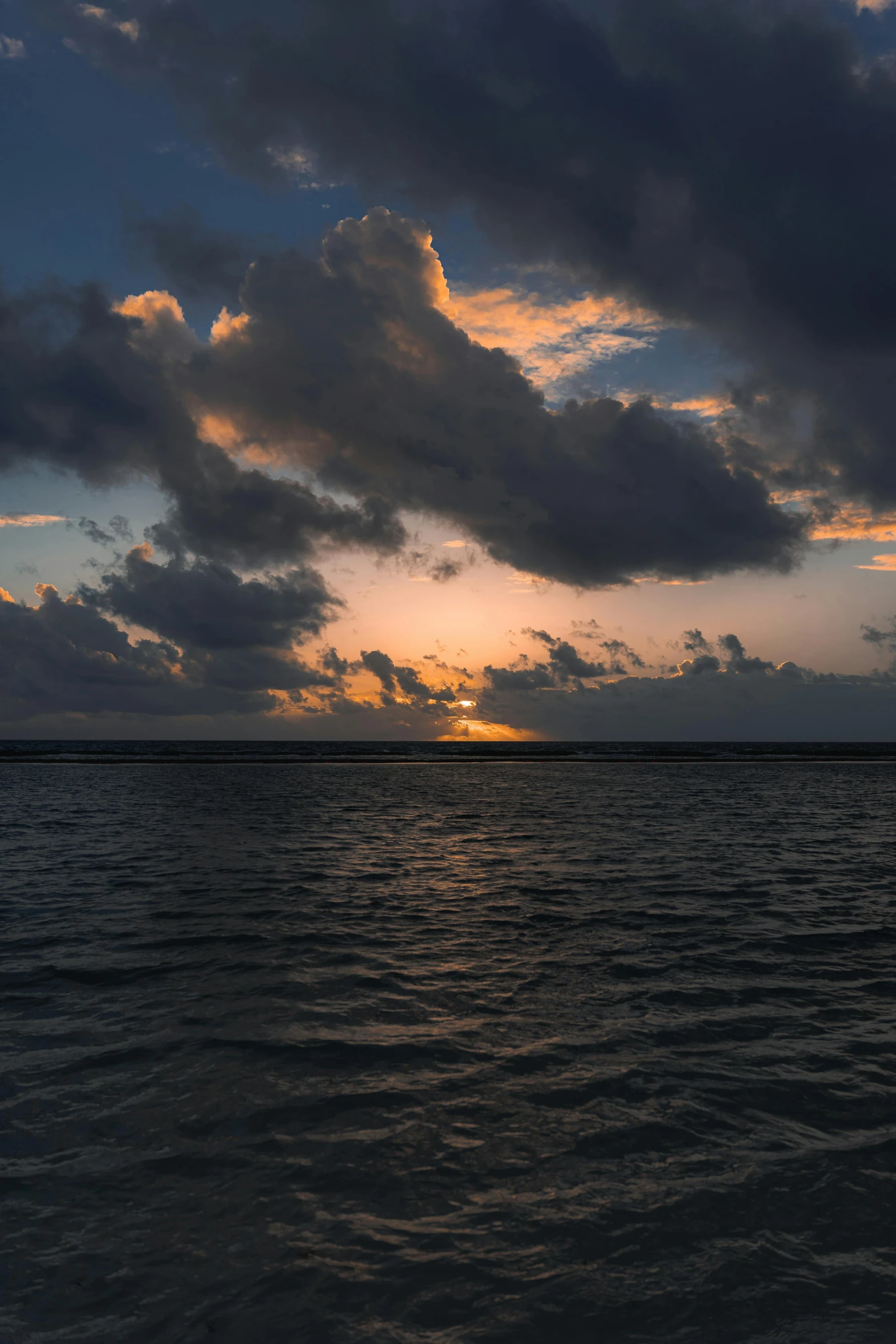 a po of sunset over the ocean from a boat