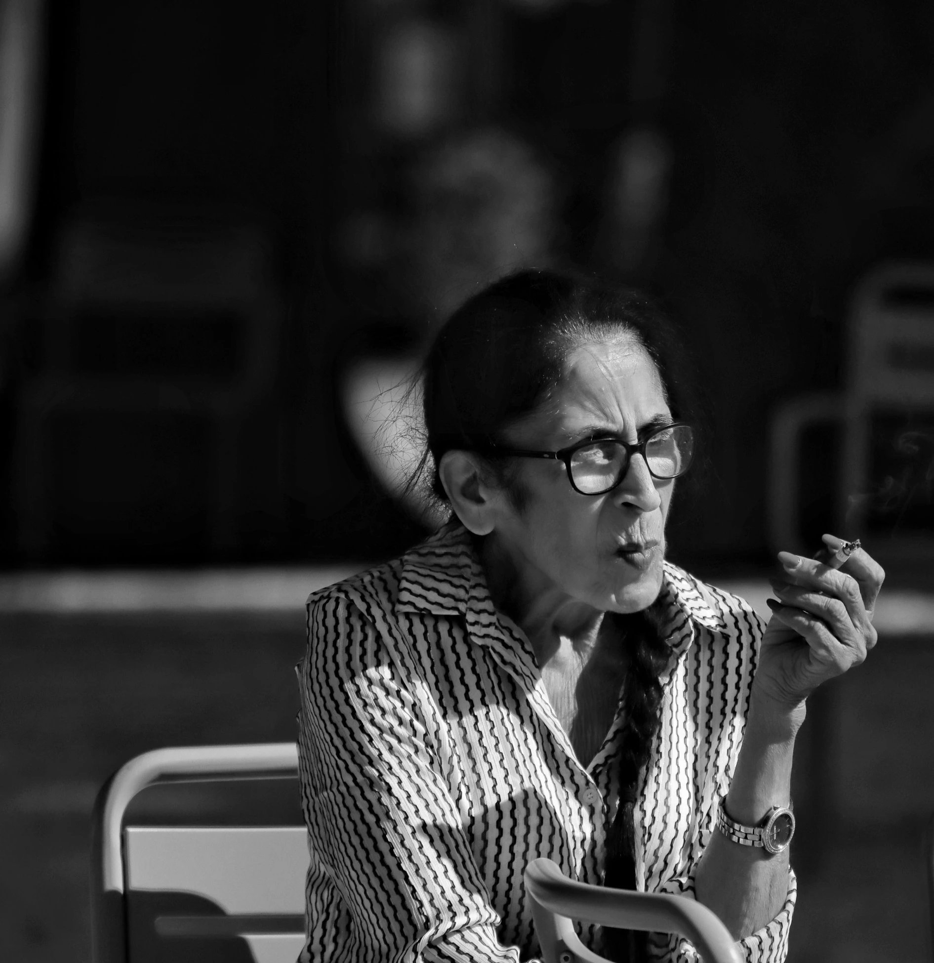 a woman sitting down smoking a cigarette