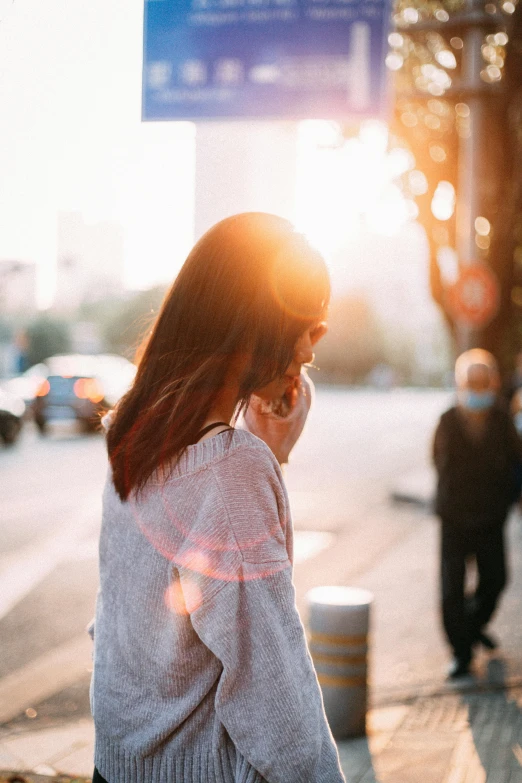 a woman standing on a sidewalk using her phone