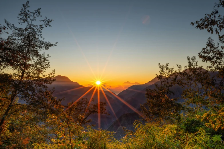 the sun is setting behind some mountains