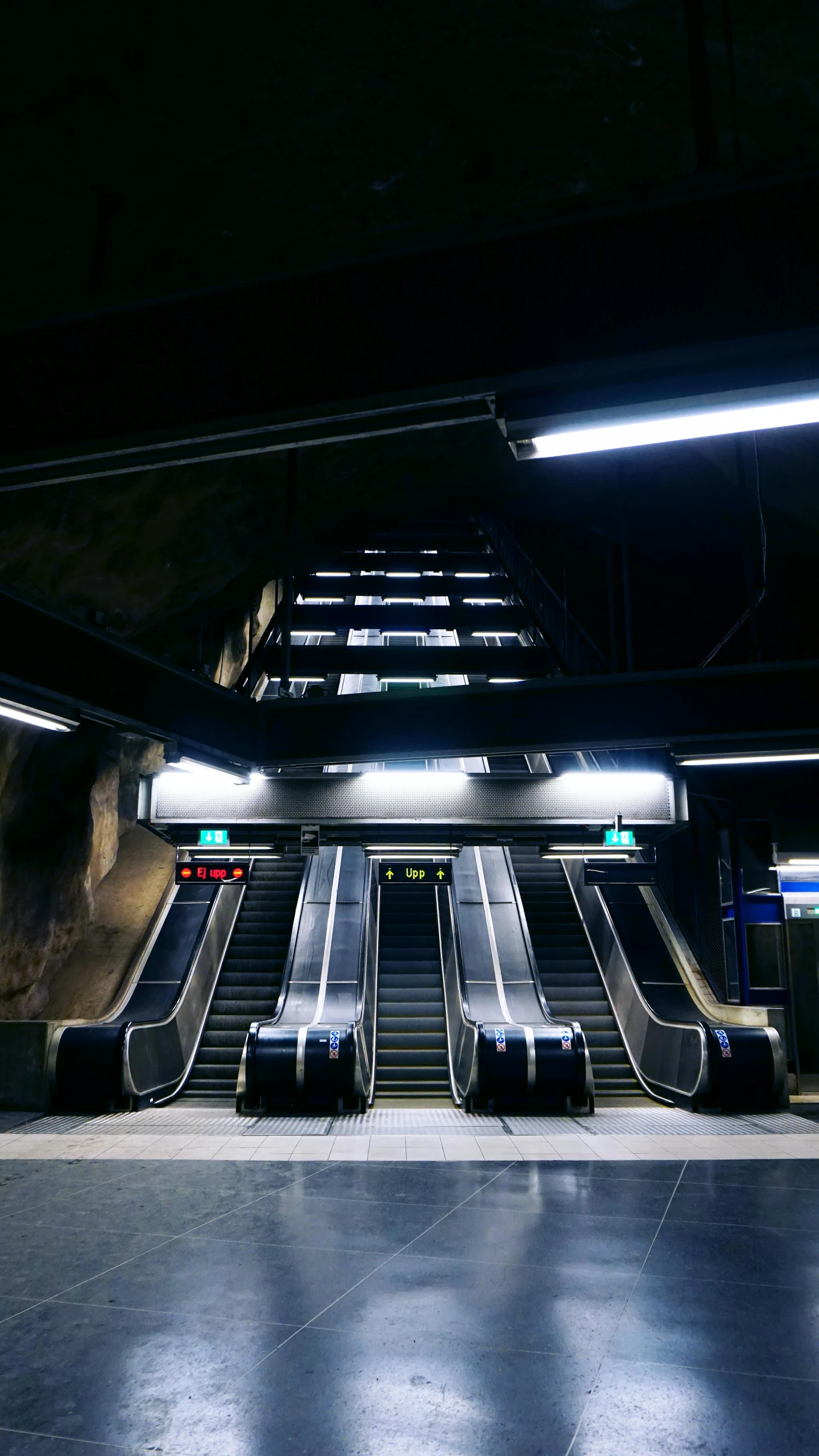 an empty subway station is lit up at night