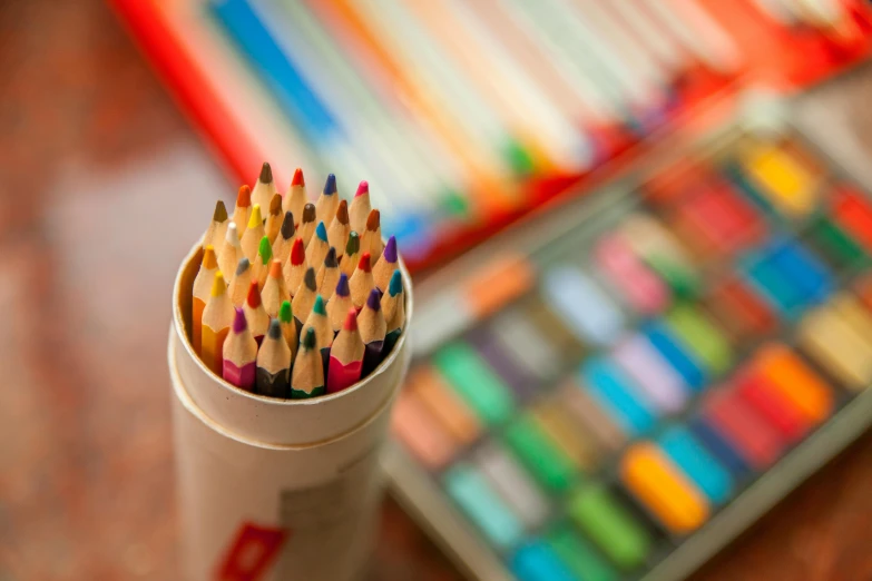 several pencils in a cup that is full of colors