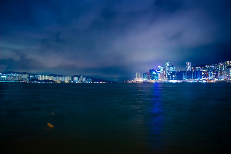 a view of a big city over the ocean at night