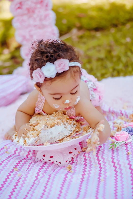 a baby sitting on the ground eating cake