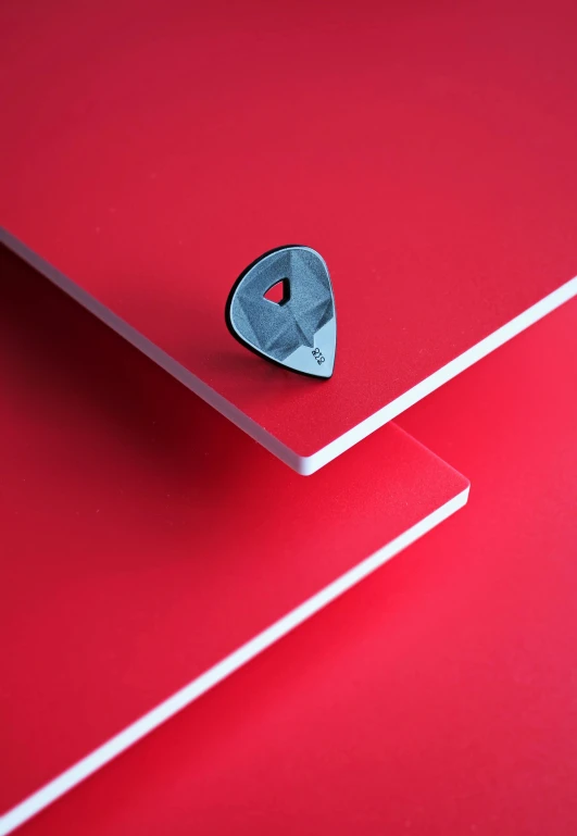 the metal object is displayed on a red surface