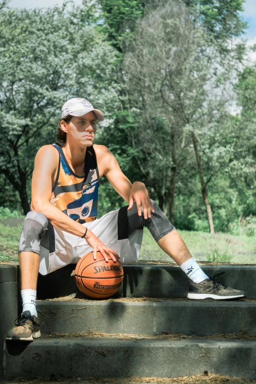 a man that is sitting with a basketball