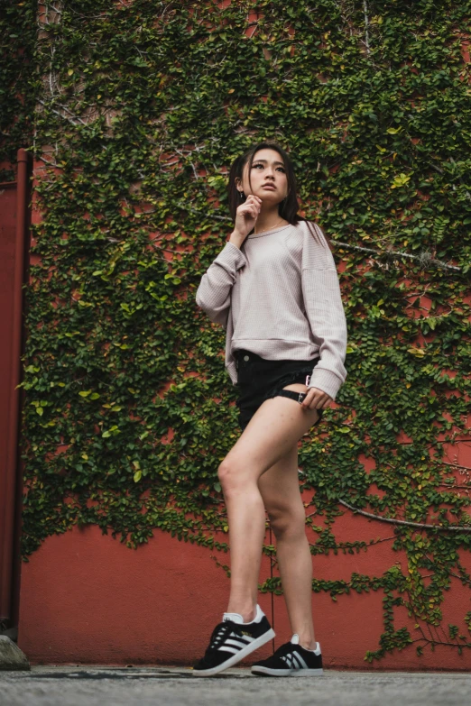 a woman standing near a green and red wall talking on a cell phone