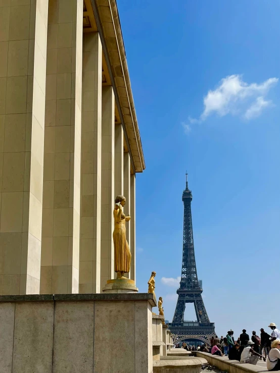 people sit next to the steps looking at the eiffel tower