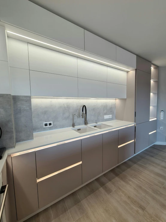 an empty kitchen with white cabinets and wood floors