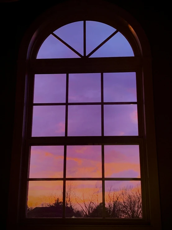 a window that has an image of the sky at sunset in it