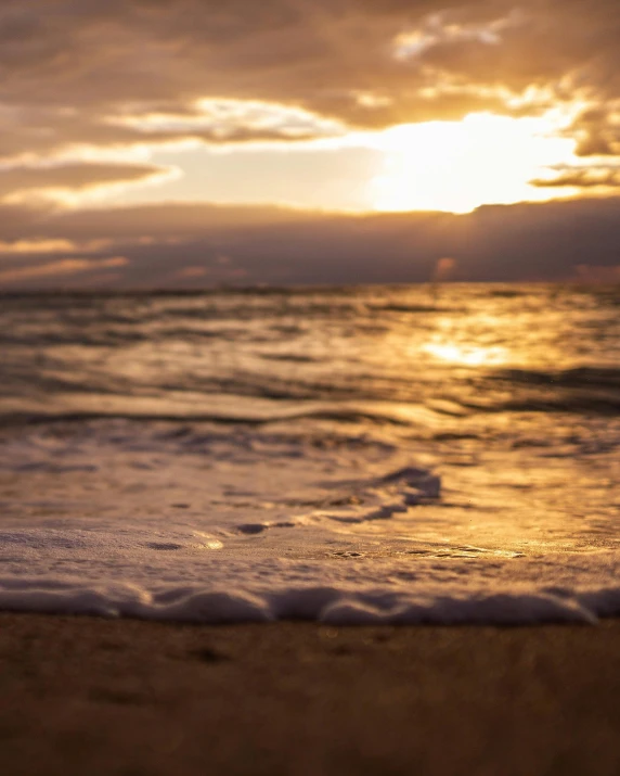 the sand has a wave coming in and it's setting