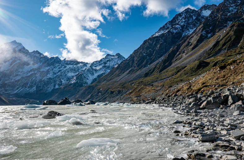 a stream is running through a mountainous valley