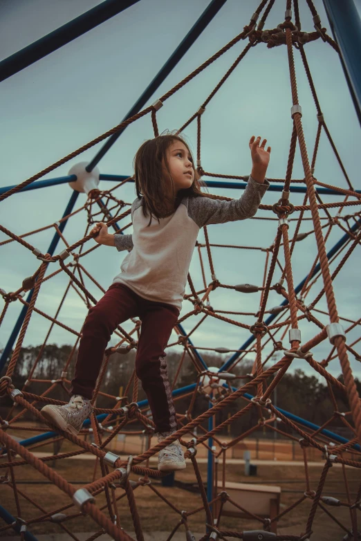 a  climbing on ropes on a small playground