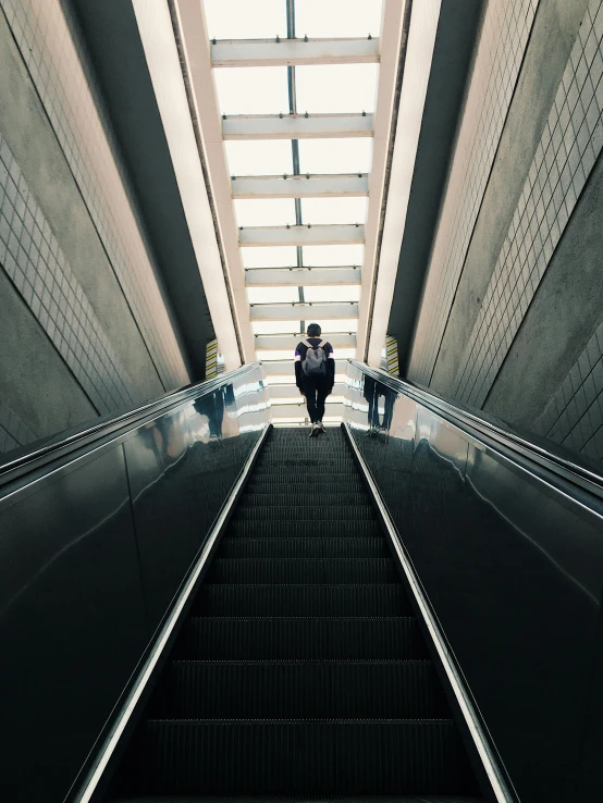 the woman walks up the escalator of an open air - force