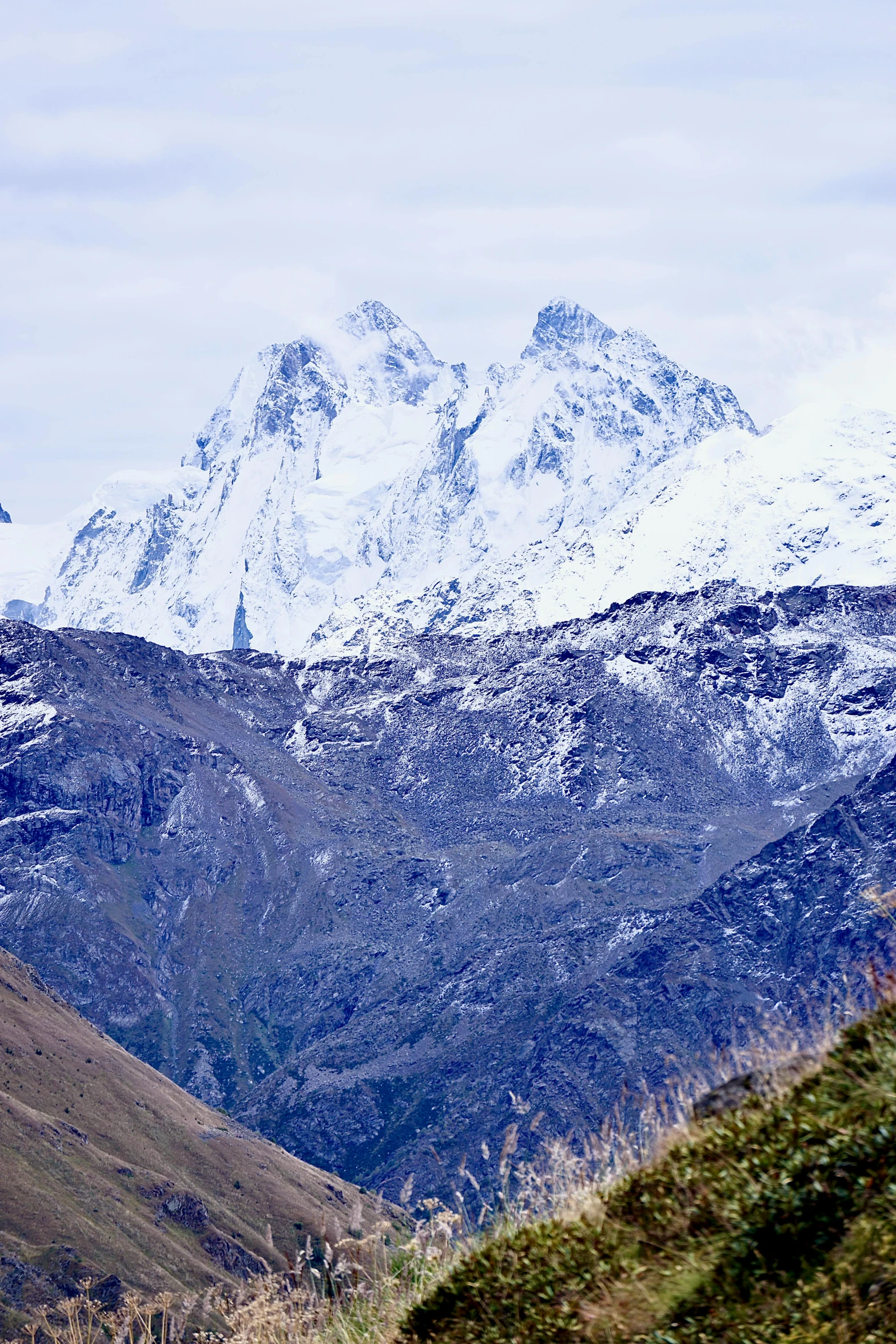 the snow - capped mountains are covered in a layer of cloud