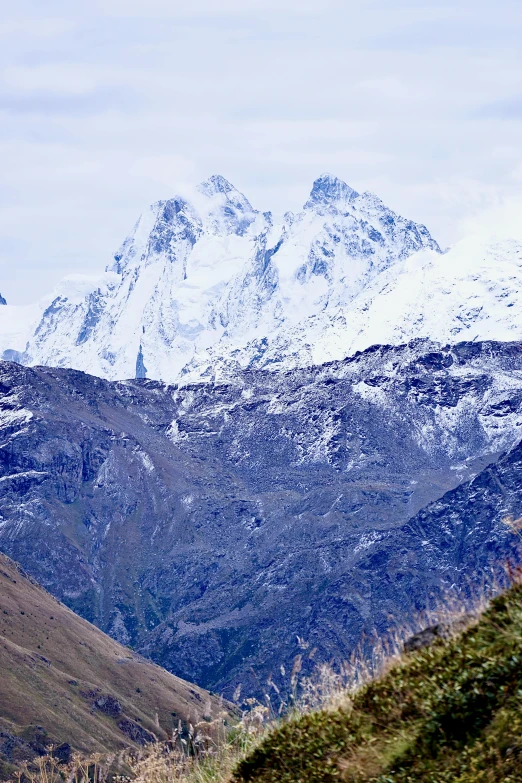 the snow - capped mountains are covered in a layer of cloud