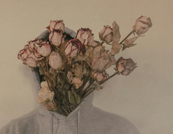 there is a hoodie with some dead flowers in front of it