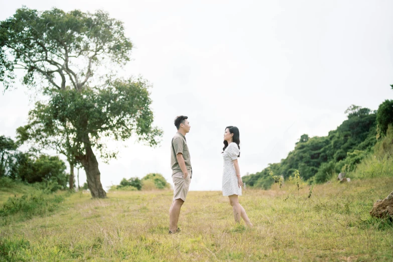 the man and woman walk through the grassy field