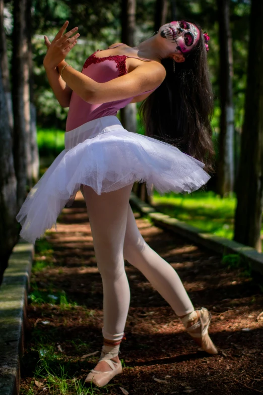 a young ballerina posing in the woods