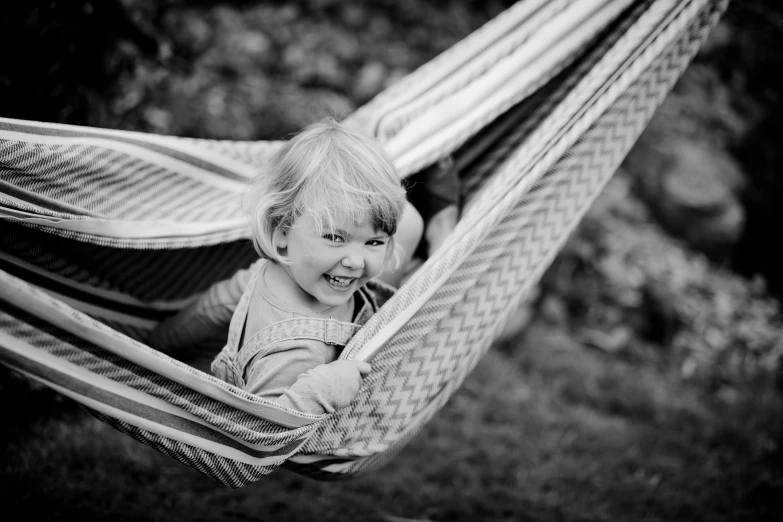 a smiling baby girl in a hammock