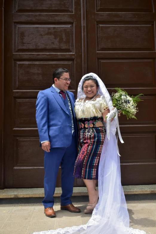 a man and a woman posing for a picture in front of a door