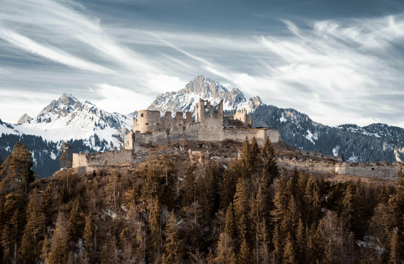 the rocky mountain side and old castle on a cloudy day