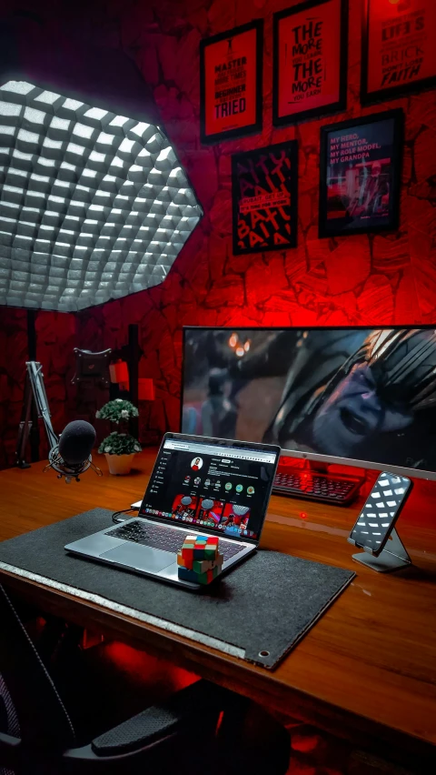 a lap top and mouse sitting on a desk in front of a monitor