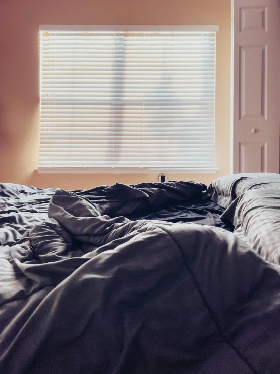 a black bed and some white walls and a window