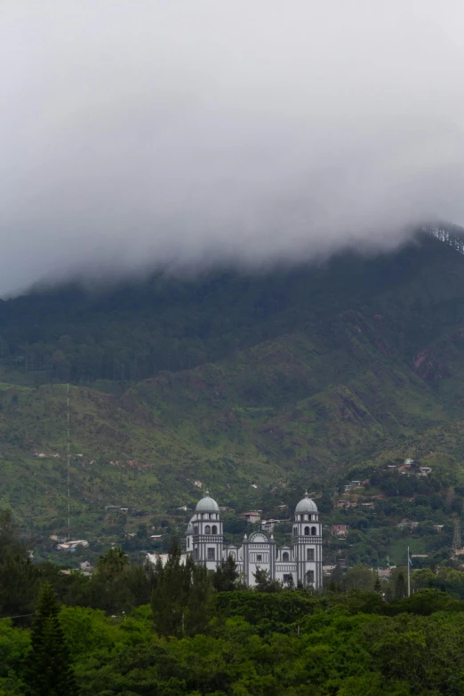 large white buildings sit in front of a mountain