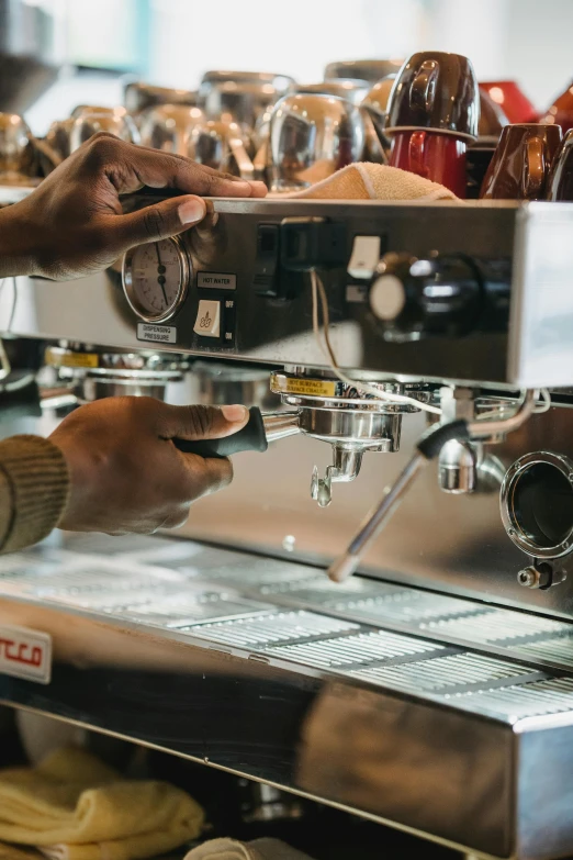 someone is using their espresso machine to make some coffee