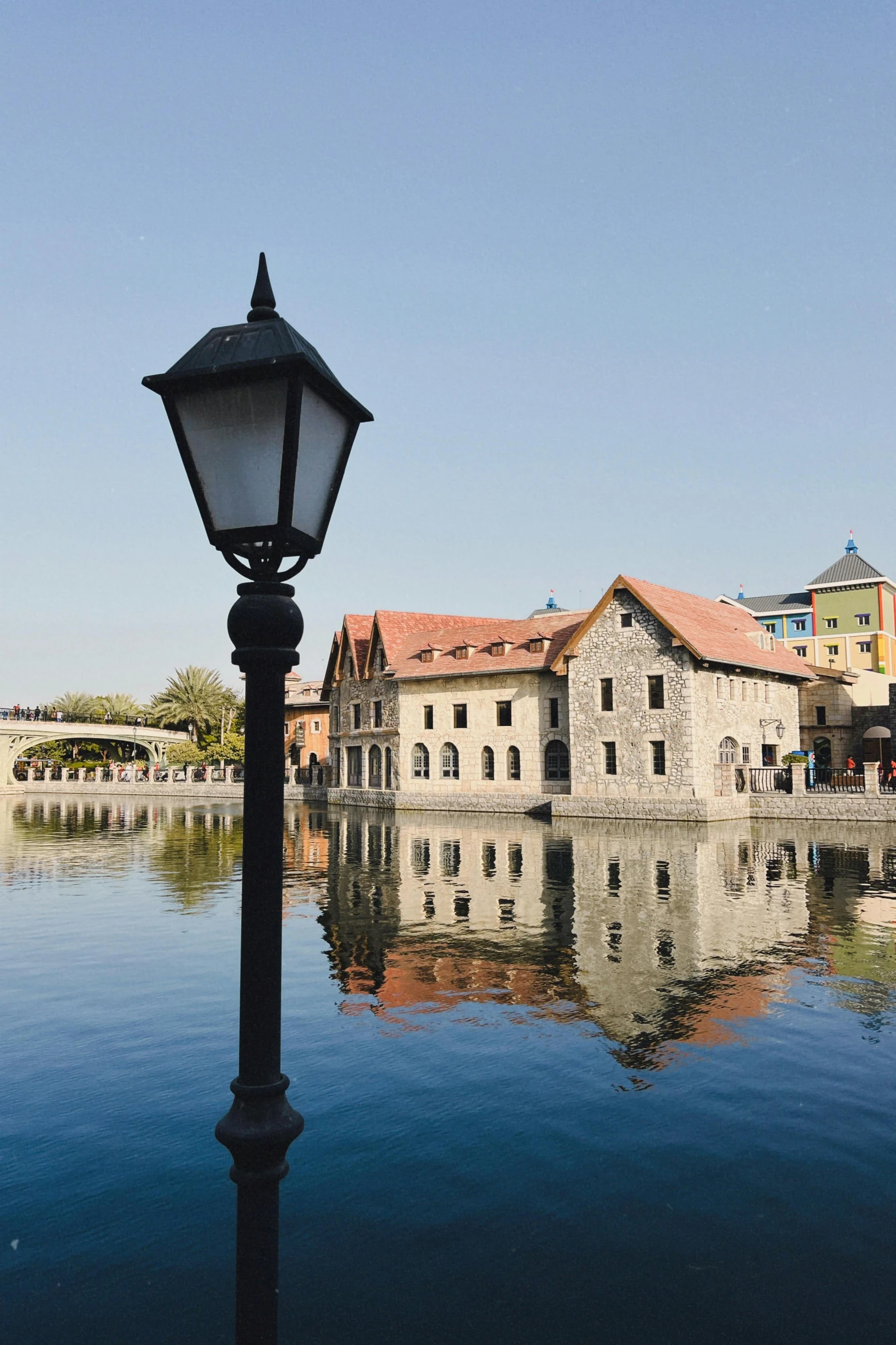 street lamp reflecting off surface of river during daytime