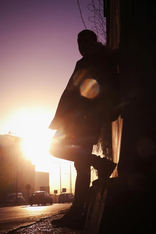 the silhouette of a man standing outside during the sun rise