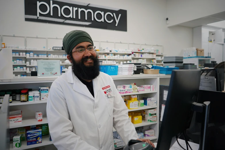 a pharmc man standing in front of a pharmacy  department