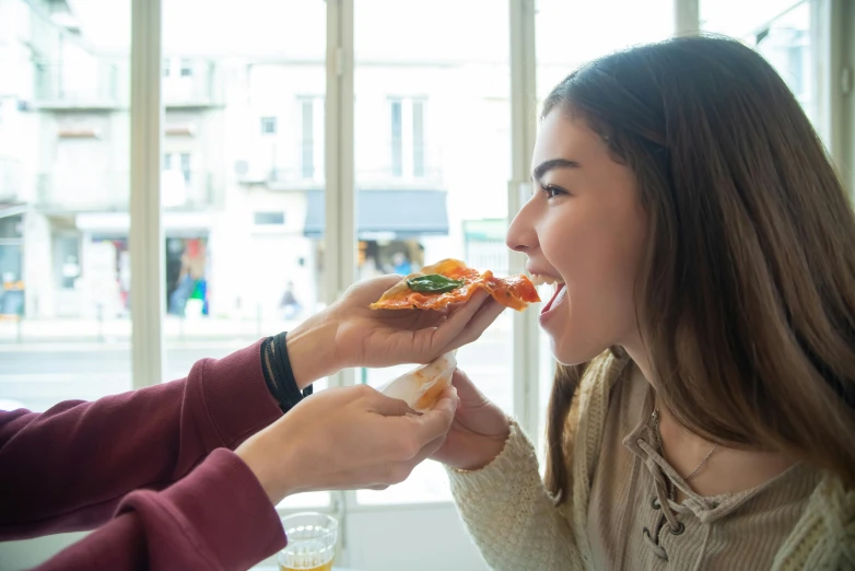 a couple of girls that are about to eat some pizza