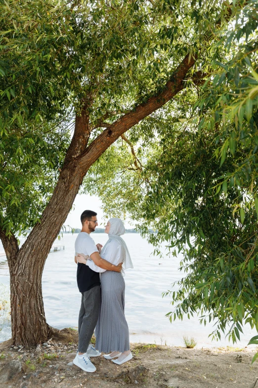 a couple emce while standing under a tree