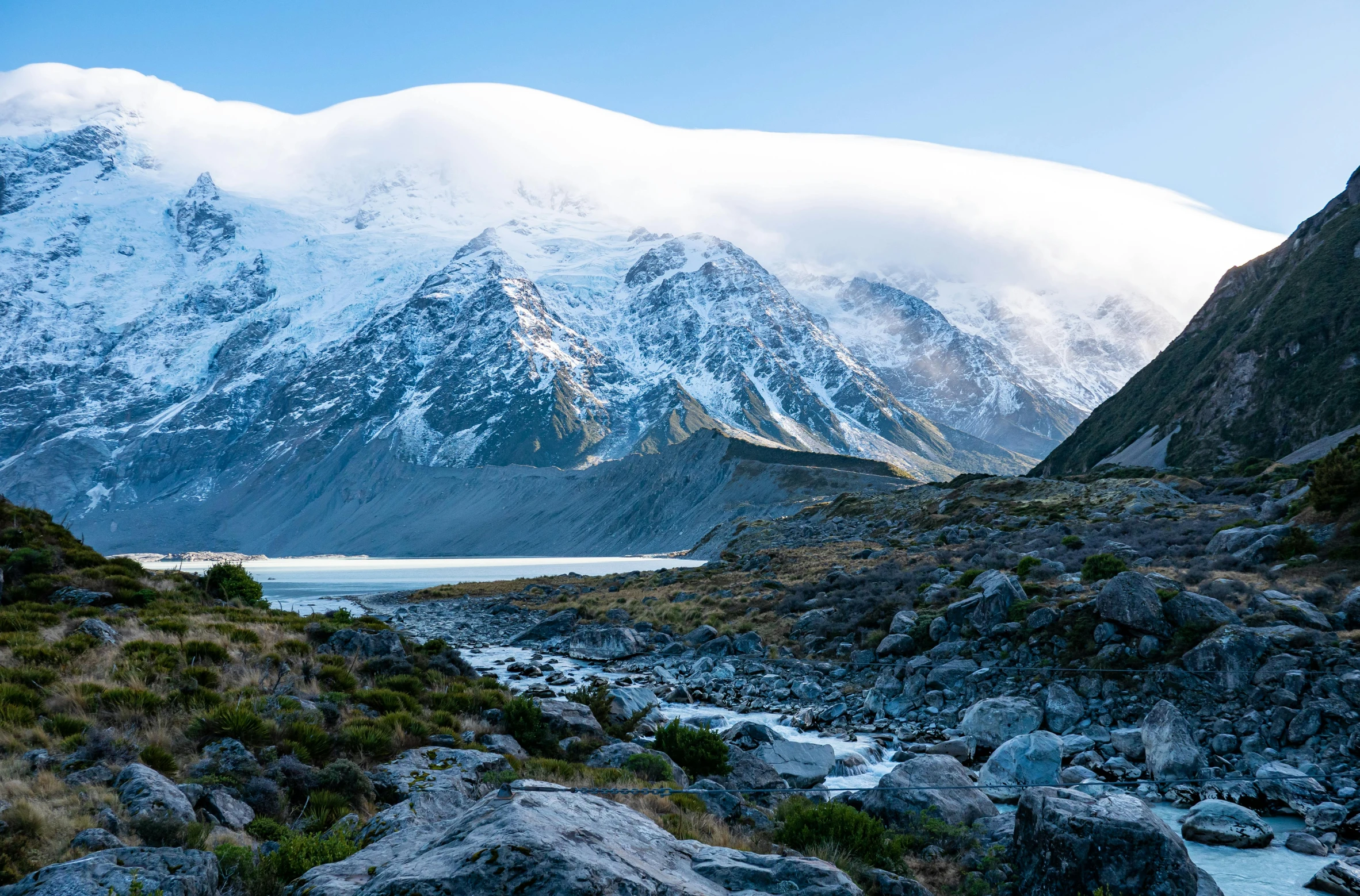 snow covered mountains surrounding a body of water