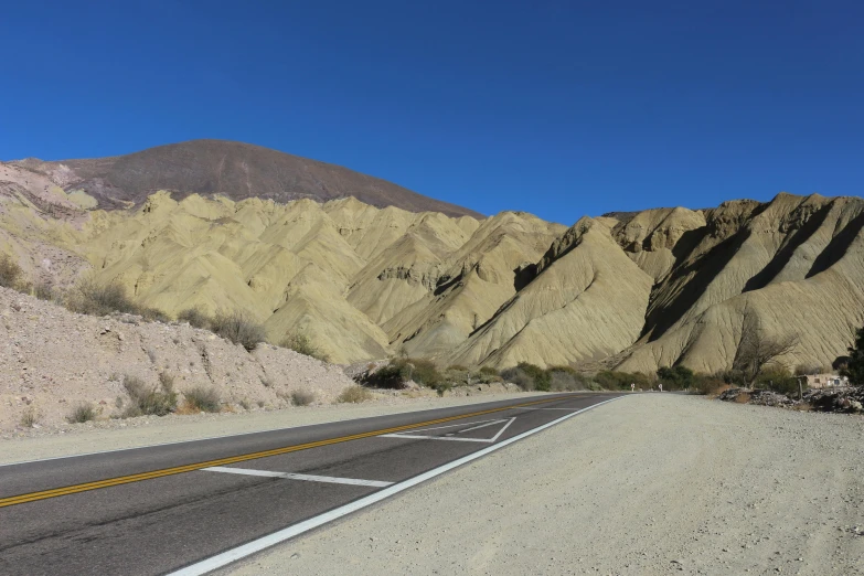 an empty road in the mountains is near an intersection