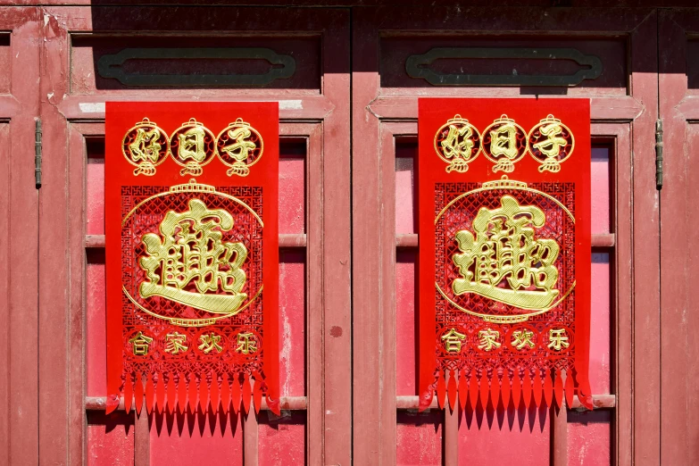 red banners with gold decorations on them hanging from an old door