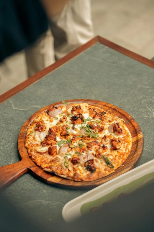 a sliced pizza with toppings on a wooden serving board