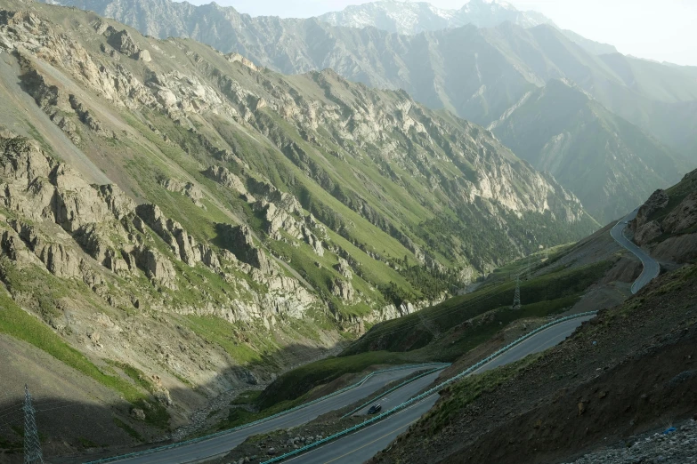 a winding road cuts into a mountainous valley